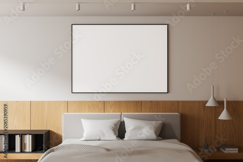 Fotografie Minimal bedroom interior featuring large blank square poster mockup above soft upholstered bed with wood panel wall and clean modern serene design