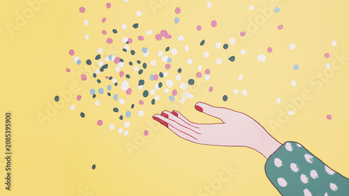 Celebratory hand with colorful confetti against yellow background