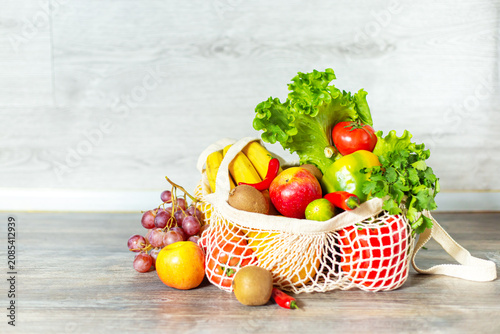 Fruits, vegetables, and greens in an  string bag. Zero-waste and healthy lifestyle concepts.