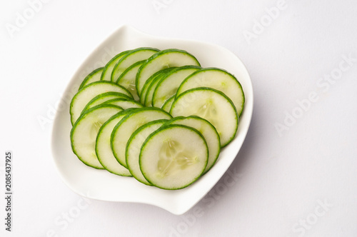 Thinly sliced cucumber in a white bowl