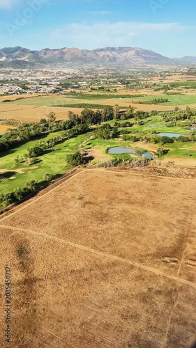 Aerial shots show the landscape of Malaga Spain with green fields, a winding river, and farmland during daylight. The different frames show natural beauty and detail.
