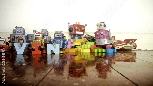 Vintage robot toys make the word VINTAGE with wooden letters in stop motion.