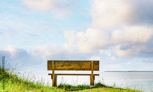 Holzbank an einem Ufer mit Blick zum Wasser