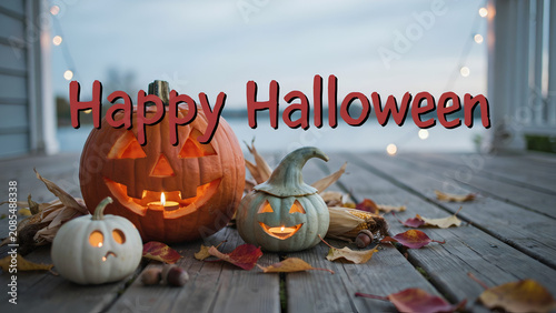 Three carved jack-o'-lantern pumpkins with candles on a wooden porch