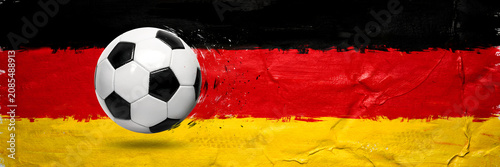 Soccer ball floating against a painted german flag background