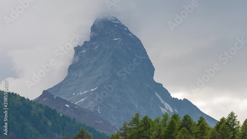 Rushing clouds over iconic Matterhorn mountain peak in Zermatt Switzerland with moving cable car below, scenic alpine landscape time lapse