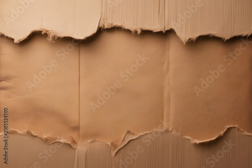 Close-up of torn brown paper with rough edges and textured surface