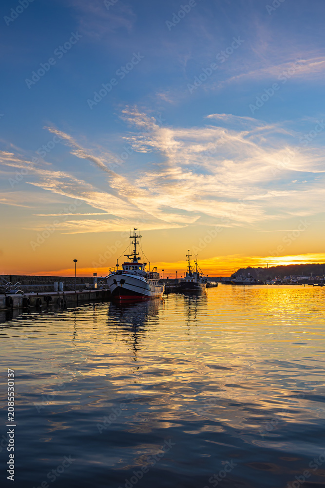Fototapeta premium Sonnenuntergang und Fischerboote im Hafen der Stadt Sassnitz auf der Insel Rügen