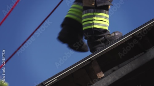 Firefighter Walking on Rooftop During Rescue Operation