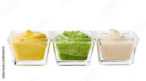 фотографія Three dipping sauces in glass ramekins mustard pesto, and aioli