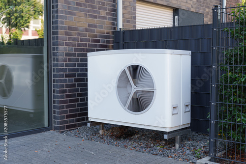 Modern outdoor air source heat pump installed beside a residential building exterior