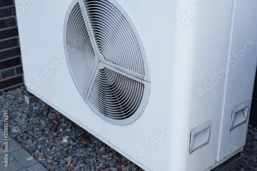 Modern outdoor air source heat pump installed beside a residential building exterior