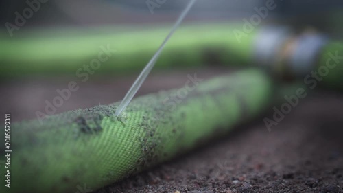 Water Leaking from Damaged Fire Hose Close Up