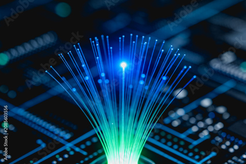Glowing optical fibers extend from a circuit board, representing high-speed data transmission and modern digital communication technology.