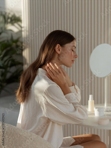 Woman performing a morning ritual at a vanity table