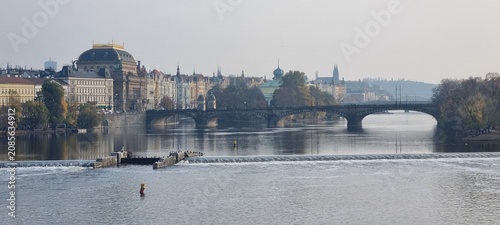 Quadro em tela Prague river view with historic bridge, National Theatre and autumn island