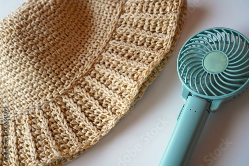 Handheld Fan and Straw Hat on White Background, Summer Heat Protection Concept