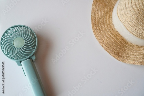 Handheld Fan and Straw Hat on White Background, Summer Heat Protection Concept