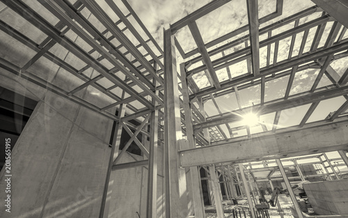 Obraz na plátně Warehouse under construction with sun rays penetrating through roof openings abo