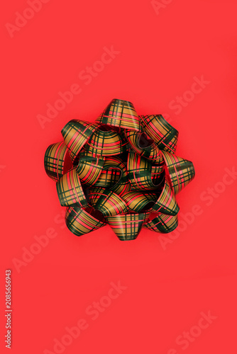 Tartan red green ribbon bow Scottish design. Vivid contrast abstract decorative background. Giving object for greeting card, birthday, anniversary.