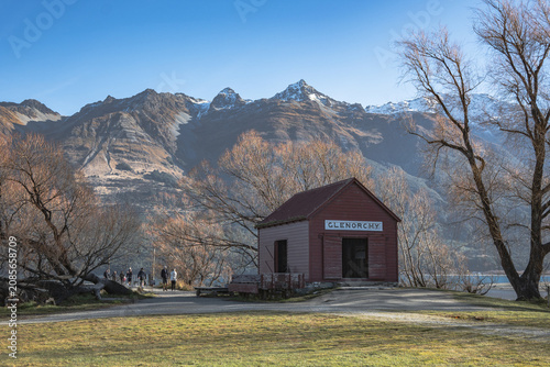 Beautiful autumn landscape of Glenorchy red shed surrounded by golden trees and mountains, Otago, New Zealand