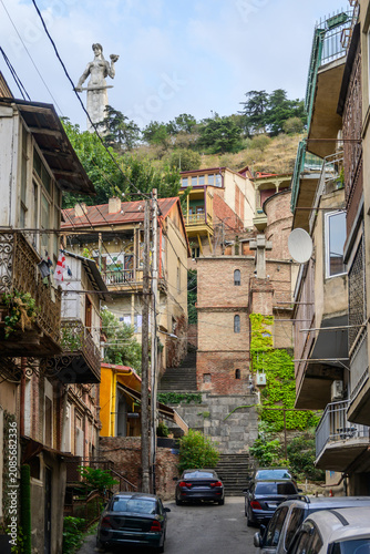 Steep Tbilisi street showcases its charming, old architecture. The Mother of Georgia (Kartlis Deda) statue gazes over the city from Sololaki hill, guarding and welcoming.
