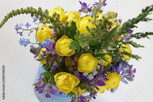Bunter Wildblumenstrauss in Vase vor hellem Hintergrund