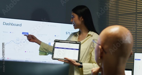 Two colleagues collaborate over a tablet and computer to brainstorm marketing ideas and financial solutions for a new project.