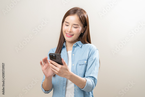 Картината върху платно Happy with phone asian young woman, girl holding mobile smart phone, read good news winning feel excited getting offer, great positive surprise, celebrate success on smartphone isolated on background