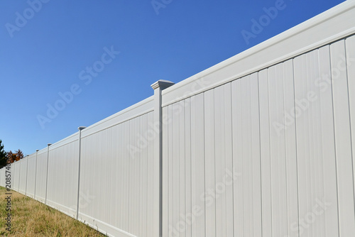 Vinyl fence stretching across open land under clear sky Generative AI