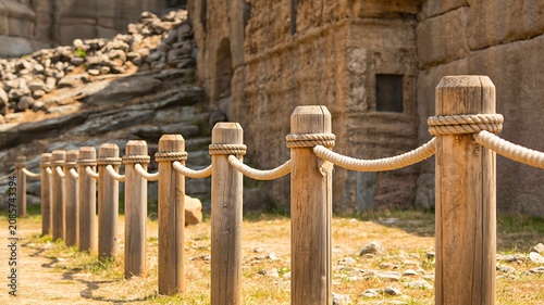 Wooden fence posts with rope barrier at historic archaeological site