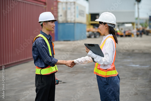 Engineers or workers shaking hands before starting to work at containers yard