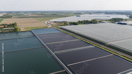 Aerial View of Floating Solar Panels Powering Industrial Greenhouses