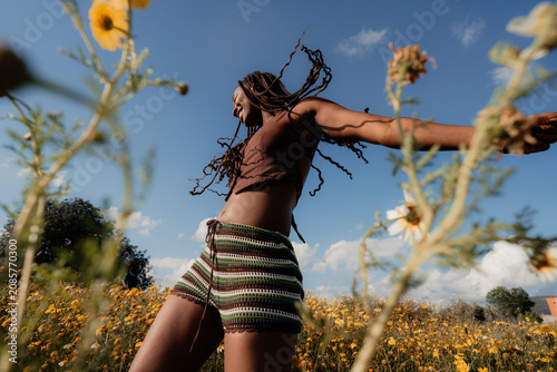 Woman Dancing in a Field of Flowers Under a Bright Sky