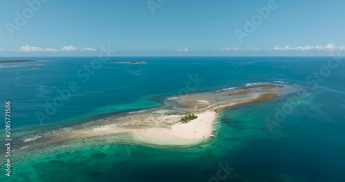 Aerial survey of Hagonoy Island with white beach and boats on shore. Britania Islands. Surigao del Sur, Philippines.