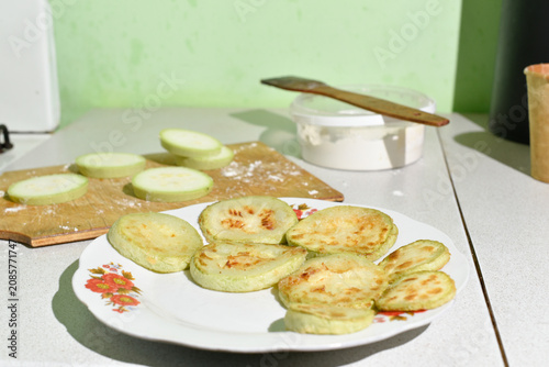 Process of frying zucchini on a wooden board in the kitchen. Ukrainian cuisine