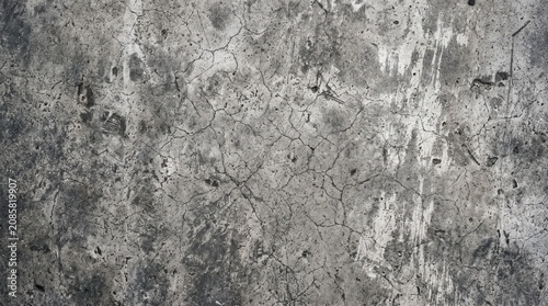 Grunge cracked concrete wall texture background with dark weathering effects
