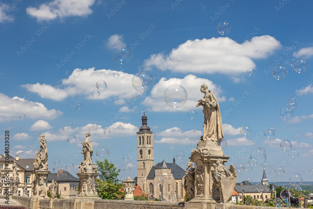 Obraz premium Famous historical town of Kutna Hora. Soap bubbles are flying in the foreground. Czech Republic.