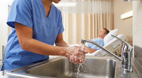 Nurse washing hands in hospital sink. Infection control and hygiene concept.
