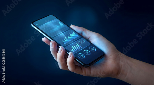 Hand holding smartphone showing professional business finance graphs and charts with smartphone business analysis investment technology financial