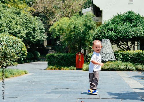 Принти на полотні Full length shot of a cute two-year-old Chinese toddler boy running and playing