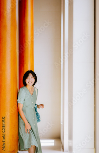 Cuadro en lienzo Portrait of a smiling Asian woman leaning against a wooden column in the Chinese
