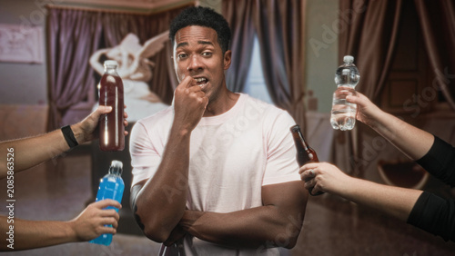 Cuadro en lienzo Man biting fingernail with arms crossed while multiple hands offer bottles in studio; peer pressure uncertainty