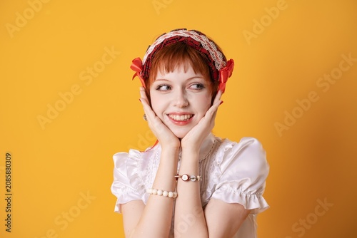 Fotografie A young girl in a studio on a yellow background