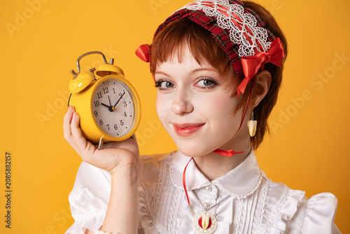 Fotografie A young girl in a studio on a yellow background