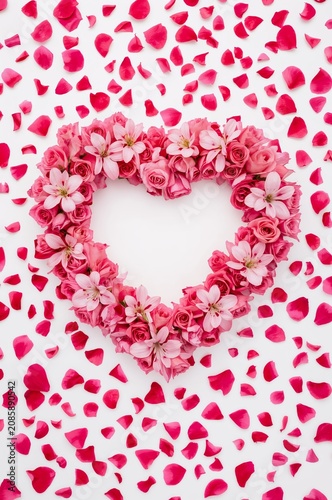 Heart Shape Made of Pink Flowers Surrounded by Rose Petals on a White Background