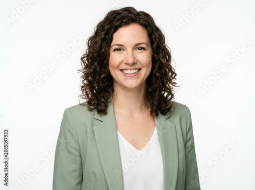 Portrait of a friendly smiling woman with curly hair wearing a green blazer