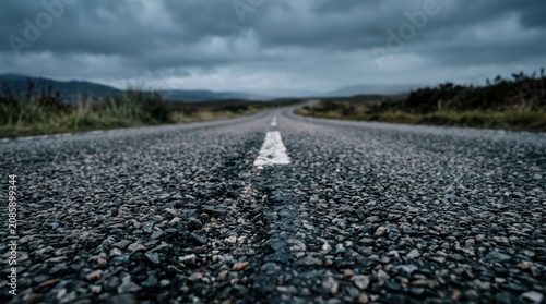 Empty asphalt highway road stretching into horizon under moody dark storm clouds