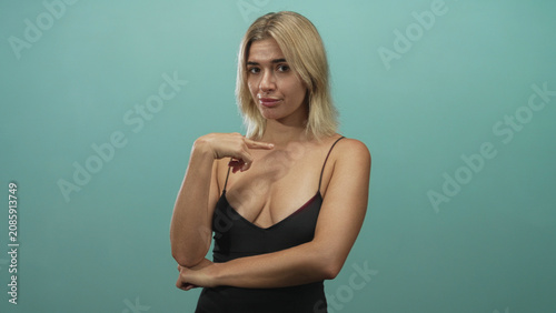 Quadro su tela Young woman points finger up with visible cleavage and eyes closed in studio set; confident dismissal