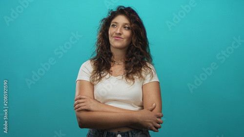 Fotografía Woman with crossed arms showing forearms and hands in studio against a turquoise wall; confidence relaxed approachable